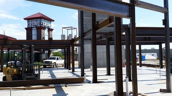 Cold Stone Creamery Butler Steel I beams frame the construction of the Catfish Bend Casino. A forklift and a flatbed truck are visible in between the beams.