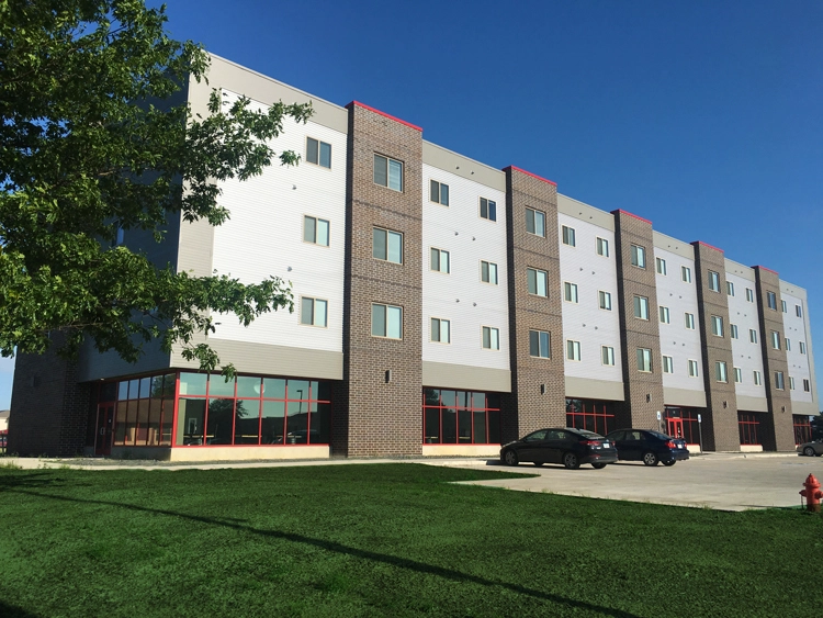 The Blackhawk Towers are seen from across the parking lot, where several cars are parked.